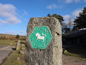 A stone marker with a green sign indicating Dartmoor National Park.