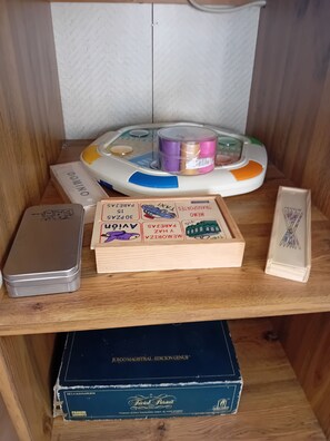 Een houten plank met een spel, een blikje en een doos met de tekst 'JUEGO MAGISTRAL'.