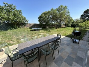 An outdoor patio with a table and chairs, a barbecue grill, and a ping pong table. - Spacious 5-bedroom house in Florensac with AC (Florensac)
