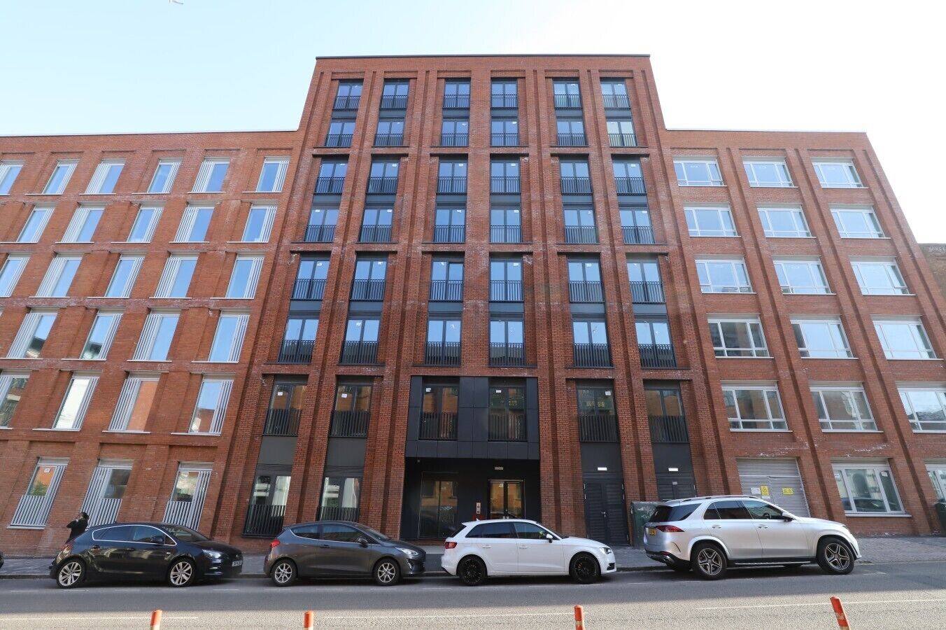 A multi-story building with a brick facade, large windows, and a central entrance.
