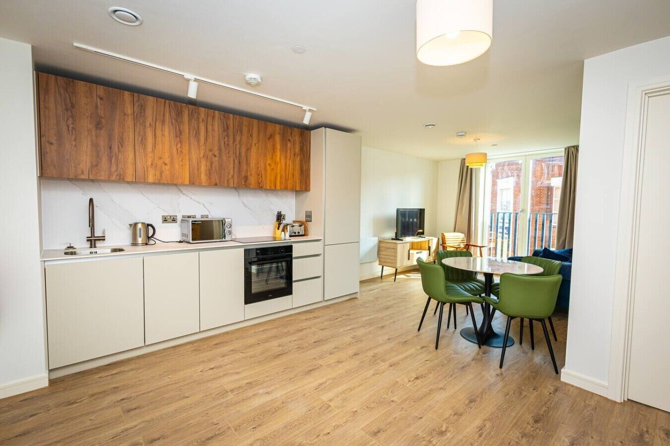 A modern kitchen with a built-in oven, microwave, and sink.