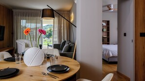En matplats med ett runt bord, stolar, en vas med blommor och en modern hänglampa.