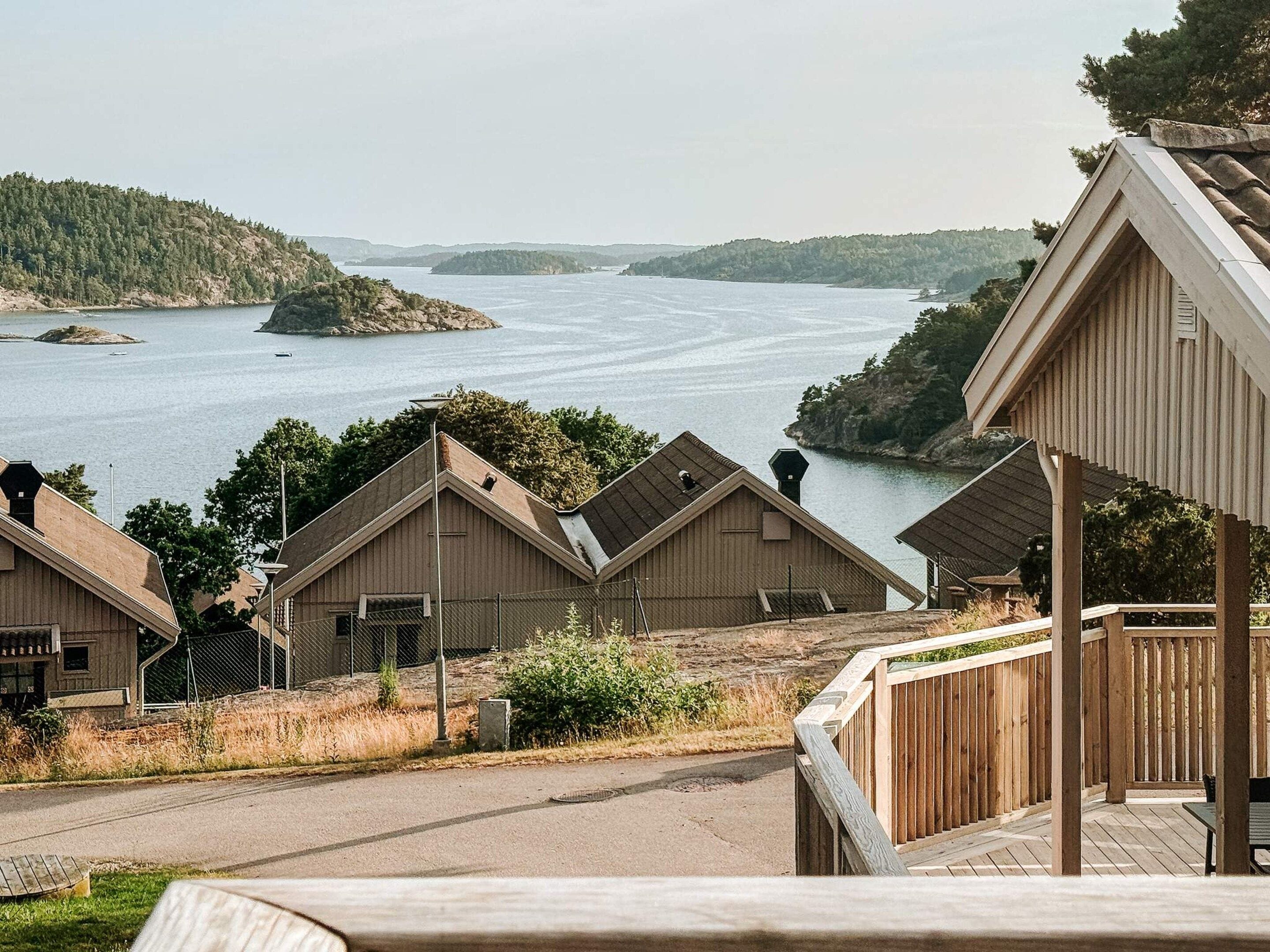 A waterfront property with multiple wooden cabins, a dock, and a view of a large body of water.