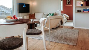 A modern living room with a dining area, a sofa set, a flat-screen TV, and a view of the outside. - 5 Star Holiday Home in Uddevalla (Uddevalla)