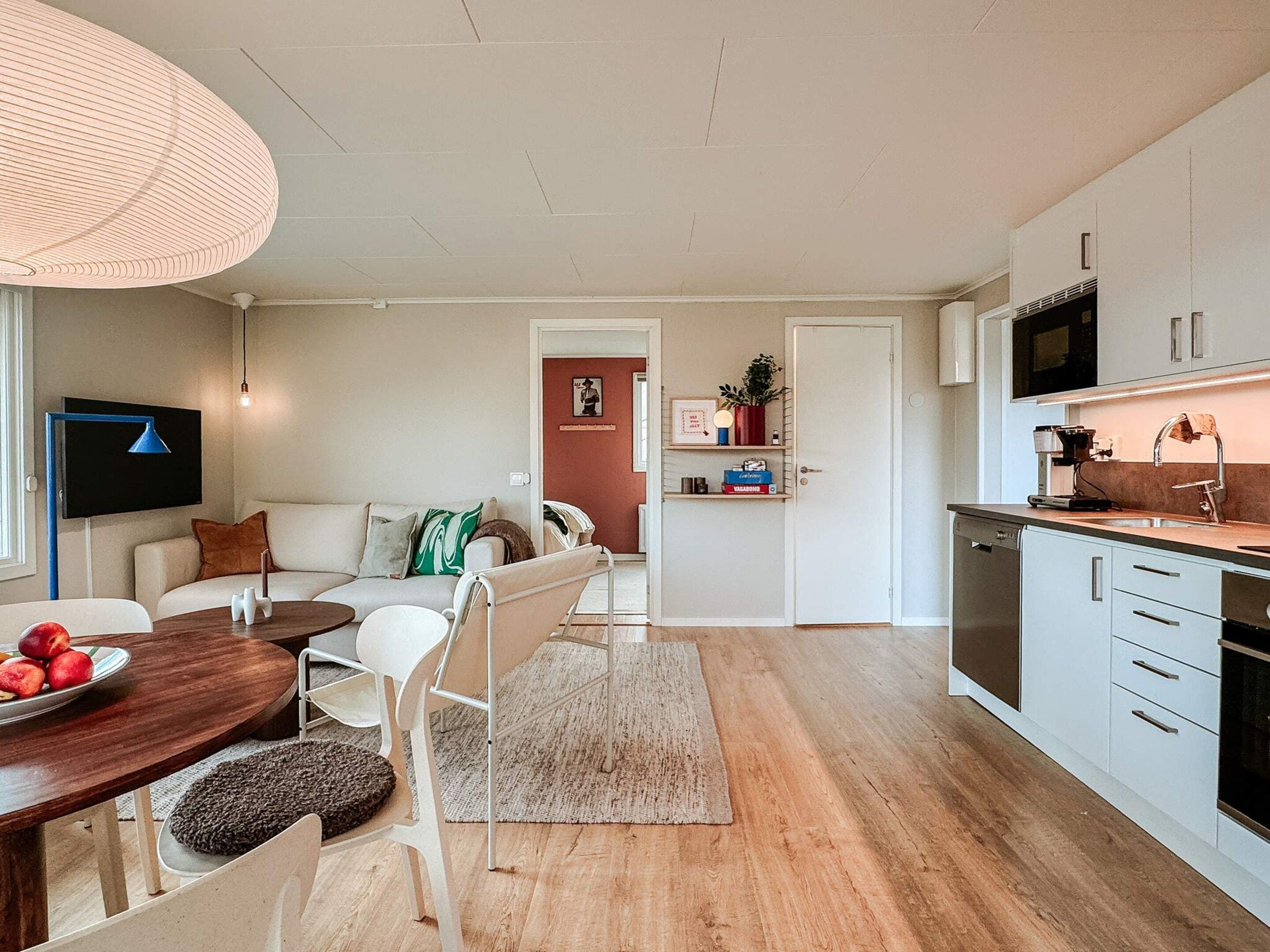 A modern kitchen with white cabinets, a microwave, and a coffee machine.