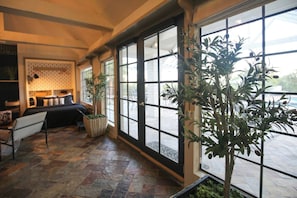 A room with a bed, a chair, a table, and a large window with a view. - Ranch Estate/ Pool / Hot Tub / Family Reunions - Holiday Home (Moorpark)