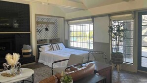 A bedroom with a bed, a seating area with a table, a fireplace, and large windows. - Ranch Estate/ Pool / Hot Tub / Family Reunions - Holiday Home (Moorpark)