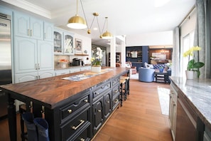 A spacious kitchen with a large island, light blue cabinets, and a modern pendant light fixture. - Ranch Estate/ Pool / Hot Tub / Family Reunions - Holiday Home (Moorpark)
