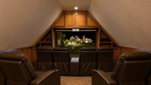 A home theater room with a sloped ceiling, a carpeted floor, and a view of a house through a window. - Ranch Estate/ Pool / Hot Tub / Family Reunions - Holiday Home (Moorpark)
