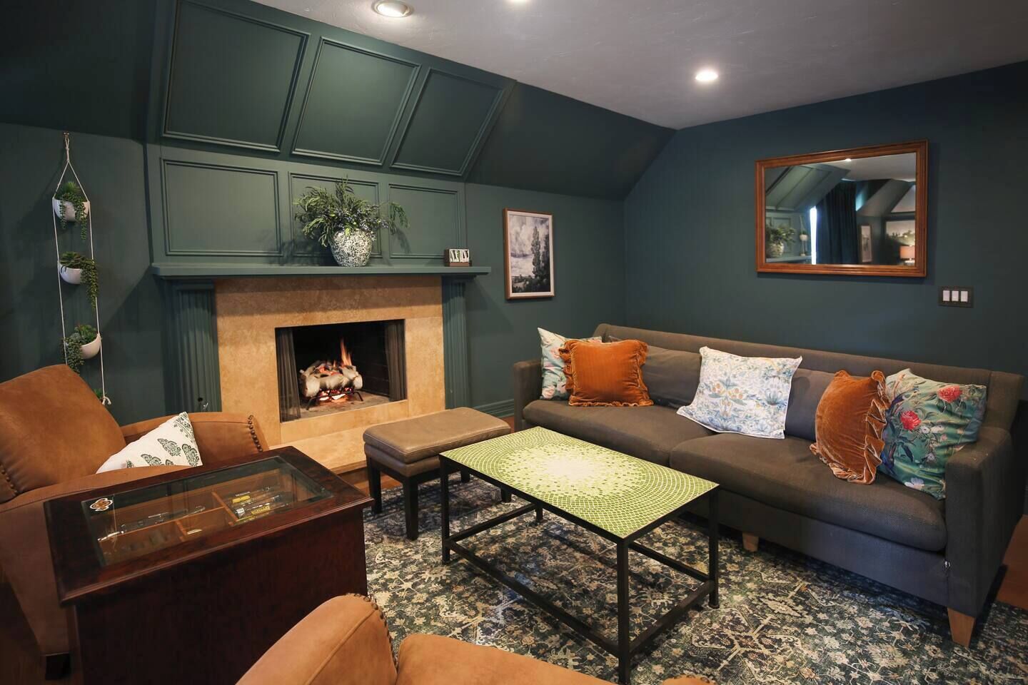 Una sala de estar con chimenea, un sofá, una mesa de centro y una mesa con superficie de vidrio.