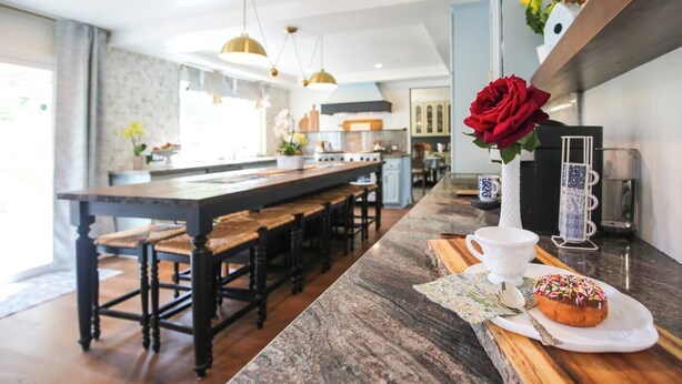 A modern kitchen with a marble countertop, wooden bar stools, pendant lighting, and a rose vase. - Ranch Estate/ Pool / Hot Tub / Family Reunions - Holiday Home (Moorpark)