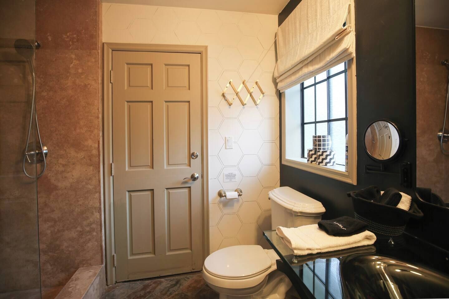 Baño con inodoro, ducha y ventana con vistas.