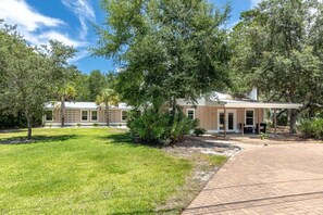 A residential property with a covered patio, a lawn, and mature trees. - Harbor Haven - New to Rental Market - 3 Bedroom near Bayou (Santa Rosa Beach)