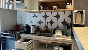 A compact kitchen with integrated storage, a built-in oven, and a patterned backsplash. - Casa Dez Guarajuba  (Camaçari)