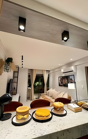 A modern living room with a sofa, a coffee table, and a lamp. - Casa Dez Guarajuba  (Camaçari)