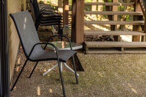 A chair with a mesh back and armrests, a glass table, and a wooden bench in a covered outdoor area. - Lakepoint Overlook | Dock + Lake Access (Bella Vista)