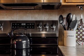 Cuina amb rellotge digital, batedora i suport per a utensilis.