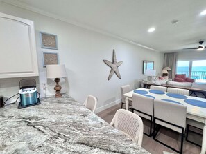 A room with a marble countertop, a starfish decoration, a ceiling fan, and a view of the ocean. - Marlin Key 2B Your Gulf-front Escape in Beautiful Orange Beach, Alabama (Orange Beach)