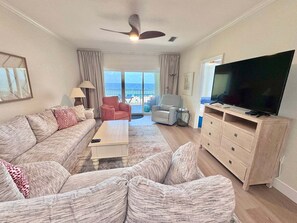 A living room with a sofa, armchairs, a coffee table, a TV, and a balcony with a view. - Marlin Key 2B Your Gulf-front Escape in Beautiful Orange Beach, Alabama (Orange Beach)