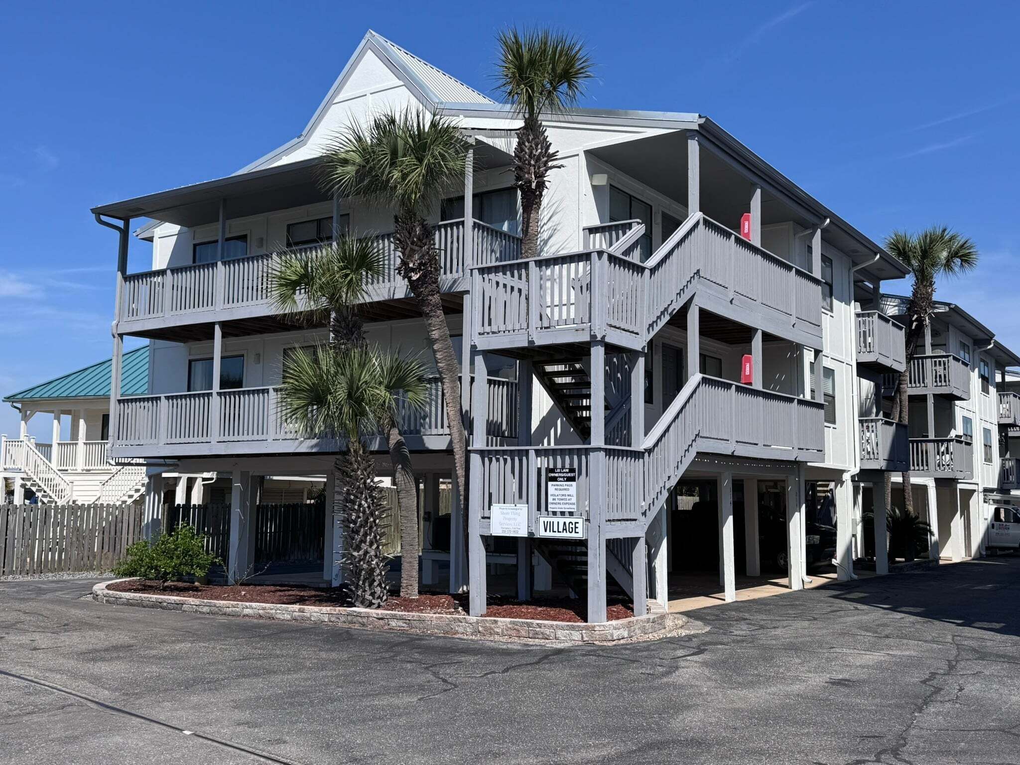 A multi-story hotel with balconies, a covered entrance, and a sign indicating 'VILLAGE.'