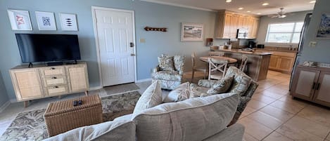 A living room with a sofa, TV, and a ceiling fan.