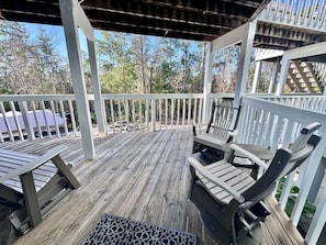 A wooden deck with a covered area, white railings, and outdoor furniture. - Welcome to This 2br/2ba Relaxing Coastal Escape (Orange Beach)