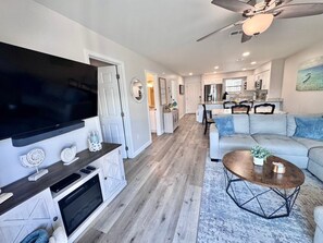 A modern living room with a flat-screen TV, a coffee table, and a sofa. - Welcome to This 2br/2ba Relaxing Coastal Escape (Orange Beach)