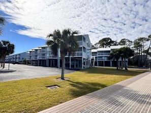 A modern hotel with multiple floors, outdoor seating areas, and a well-maintained lawn. - Welcome to This 2br/2ba Relaxing Coastal Escape (Orange Beach)