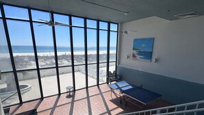 A room with large windows, a table, a chair, and a painting on the wall. - Welcome to a Beautifully Updated 2br/2ba Gulf-front Escape (Orange Beach)