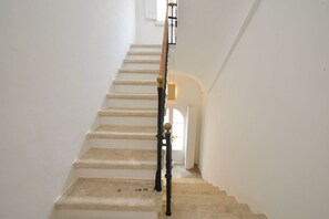 A staircase with a handrail and a light fixture at the top. - White Horizon Ostuni – Luxury Home in Center (Puglia)