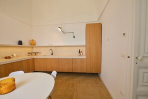 A modern kitchen with wooden cabinets, a white countertop, a sink, and a pendant light. - White Horizon Ostuni – Luxury Home in Center (Puglia)