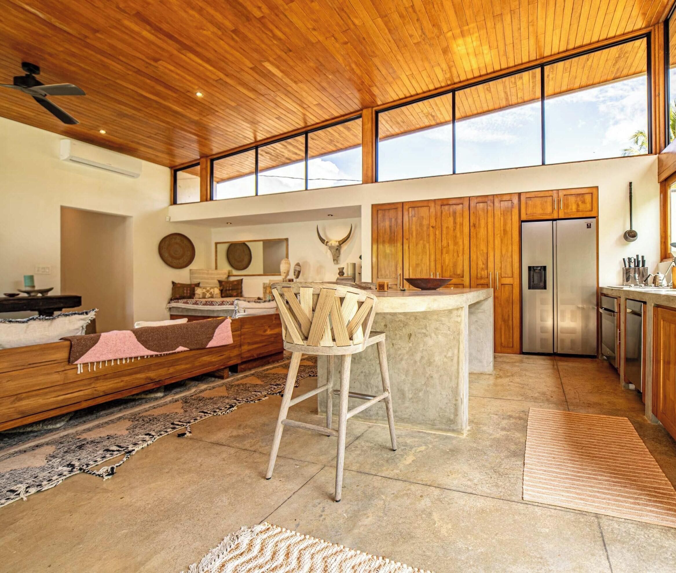 A spacious kitchen with wooden cabinets, a large island, and a built-in refrigerator.