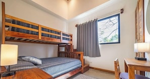 A room with a bunk bed, a desk, a chair, a lamp, and a window with curtains. - Casa del Pez in Playa Pelada (Nosara)