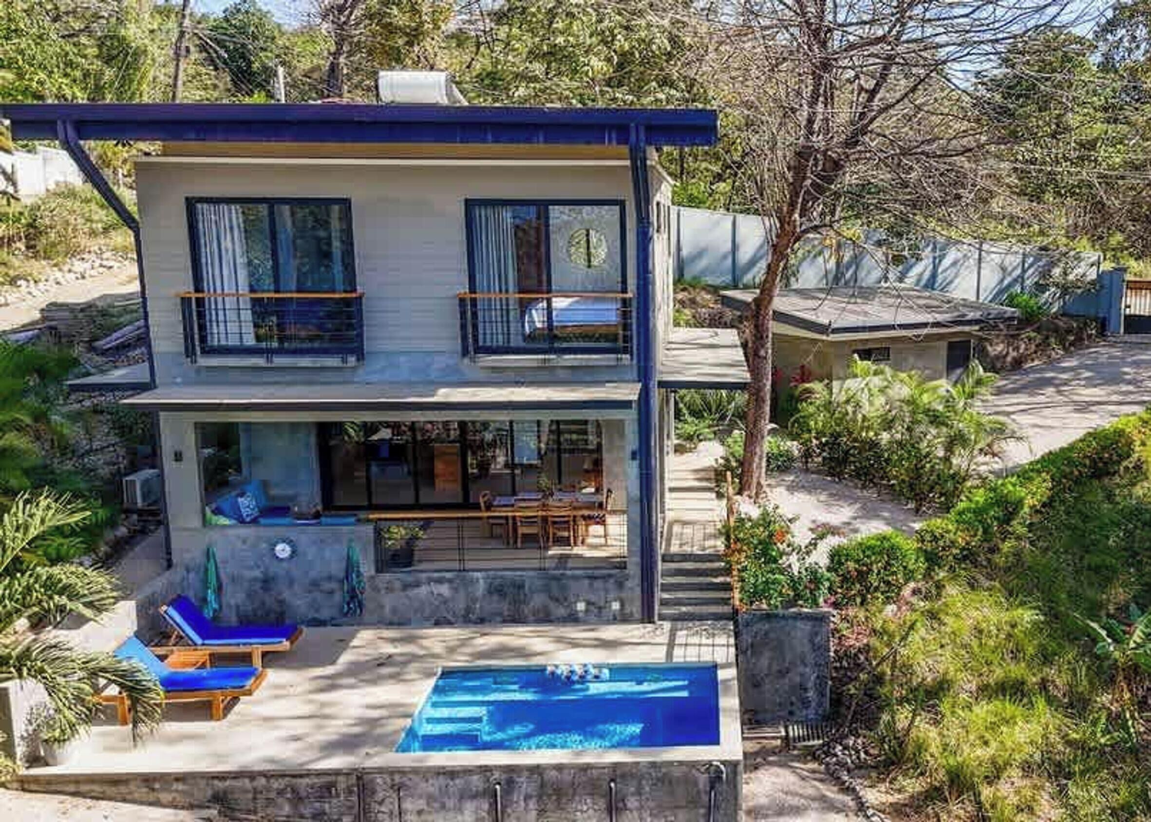 Une maison à deux étages dotée d’un balcon, d’une piscine et d’un espace patio.