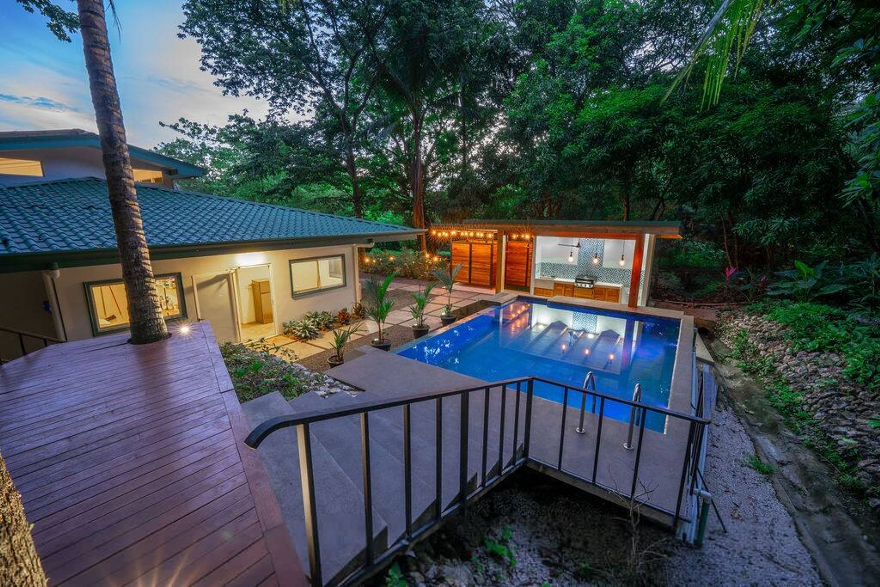 Una casa moderna con piscina, terrazza e giardino.