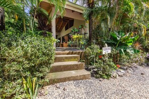 A tropical resort entrance with a stone staircase leading to a covered area, surrounded by lush greenery and a sign indicating parking area #6. - Casa Carlita at Hidden Palms (Nosara)