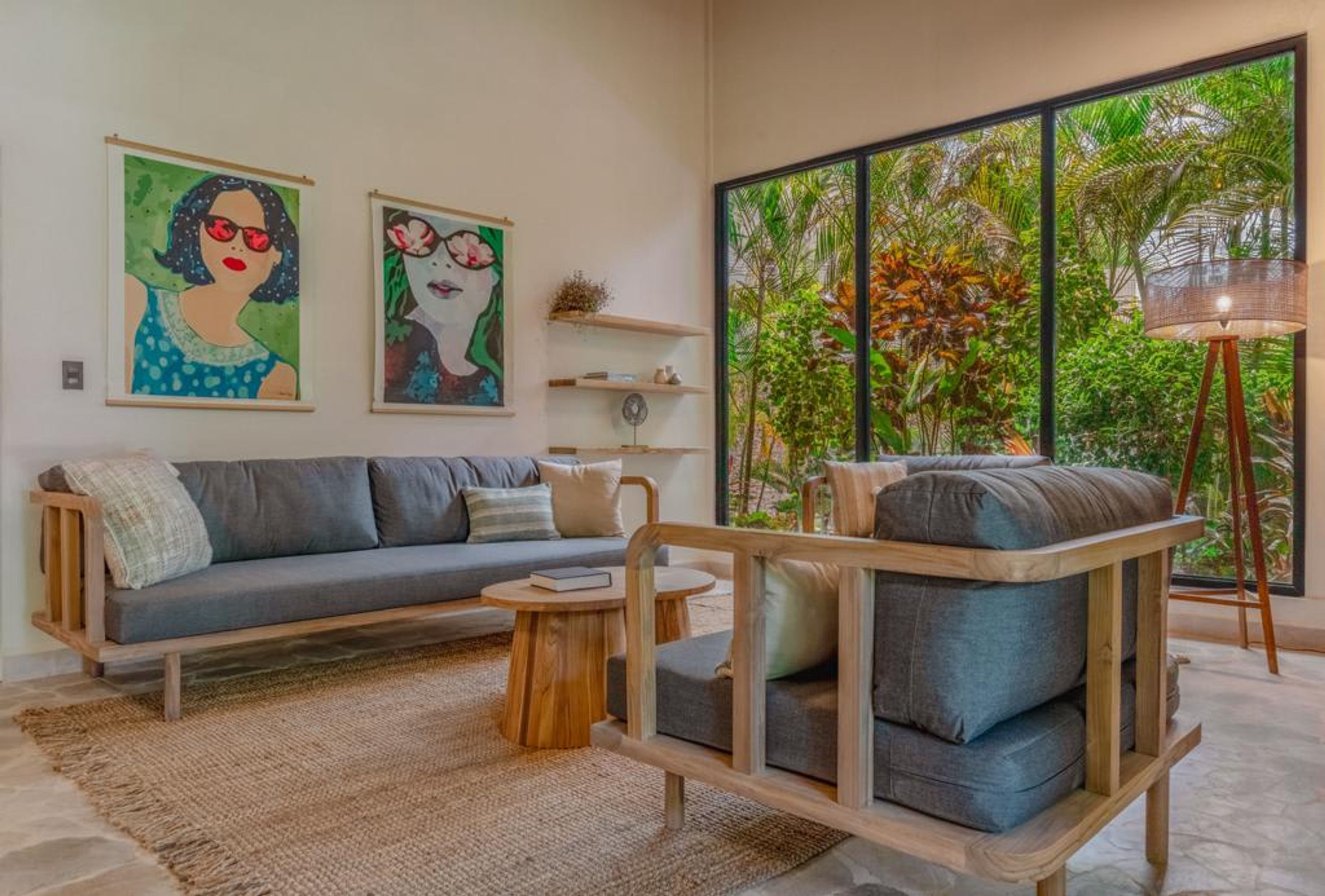 Una sala de estar moderna con sofá, sillón, mesa de centro y una obra de arte en la pared.