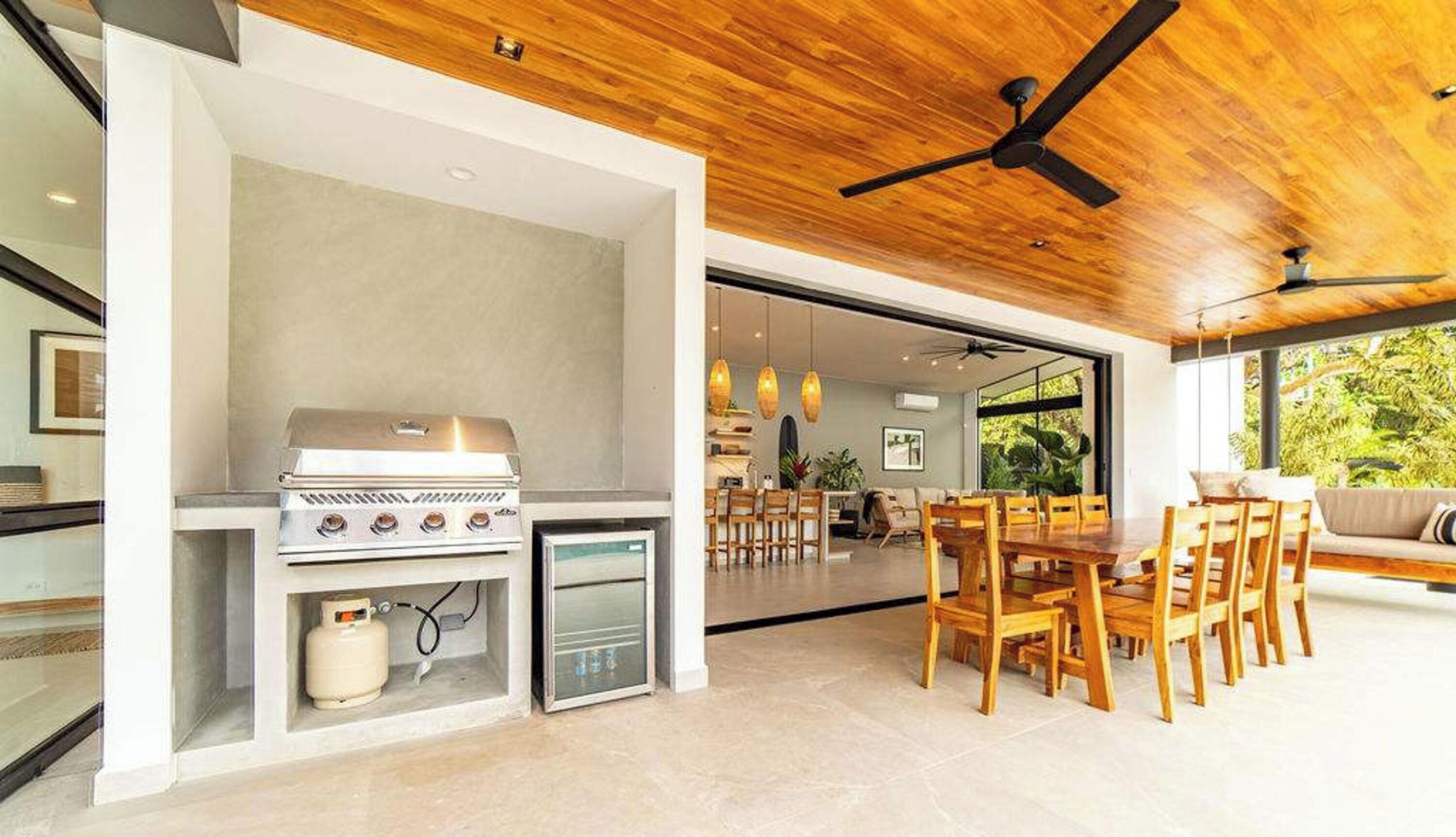 Un espacio habitable de concepto abierto con una parrilla empotrada, zona de comedor y ventanas amplias.