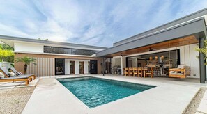 A modern house with a swimming pool, outdoor seating, and a dining area. - Casa Ocaso - 4BR - Private Pool - Walk to Beach (Nosara)