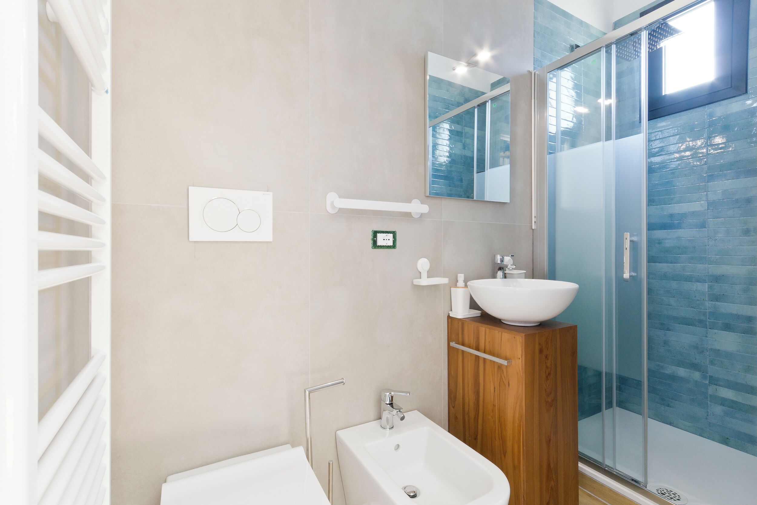 A modern bathroom with a bathtub, a wooden vanity, a glass shower enclosure, and a wall-mounted mirror.