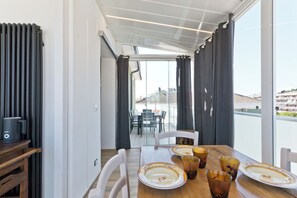 A dining area with a table set for four, a radiator, and a view of the outside. - Pescara Beach Tramonto (Pescara)