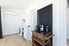 A compact kitchen with a washing machine, a coffee maker, and a radiator. - Pescara Beach Tramonto (Pescara)