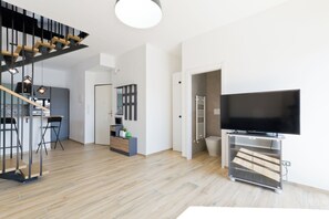 A modern living room with a flat-screen TV, a staircase, and a dining area. - Pescara Beach Tramonto (Pescara)