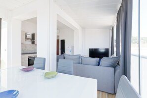Ein stilvoller Wohnbereich mit Esstisch, Sofa und Fernseher.