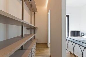 A modern interior with a wooden bench, metal shelving, and a view of a balcony with a bed. - Pescara Beach Alba - One Bedroom Apartment, Sleeps 4 (Pescara)