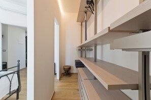 Ein moderner Hotelkorridor mit Holzboden, einem Metallbettgestell und einer eingebauten Sitzbank mit Regalen.