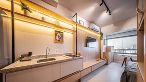 Eine moderne Küche mit Backofen, Spüle und Fenster mit Blick auf eine Stadtlandschaft.