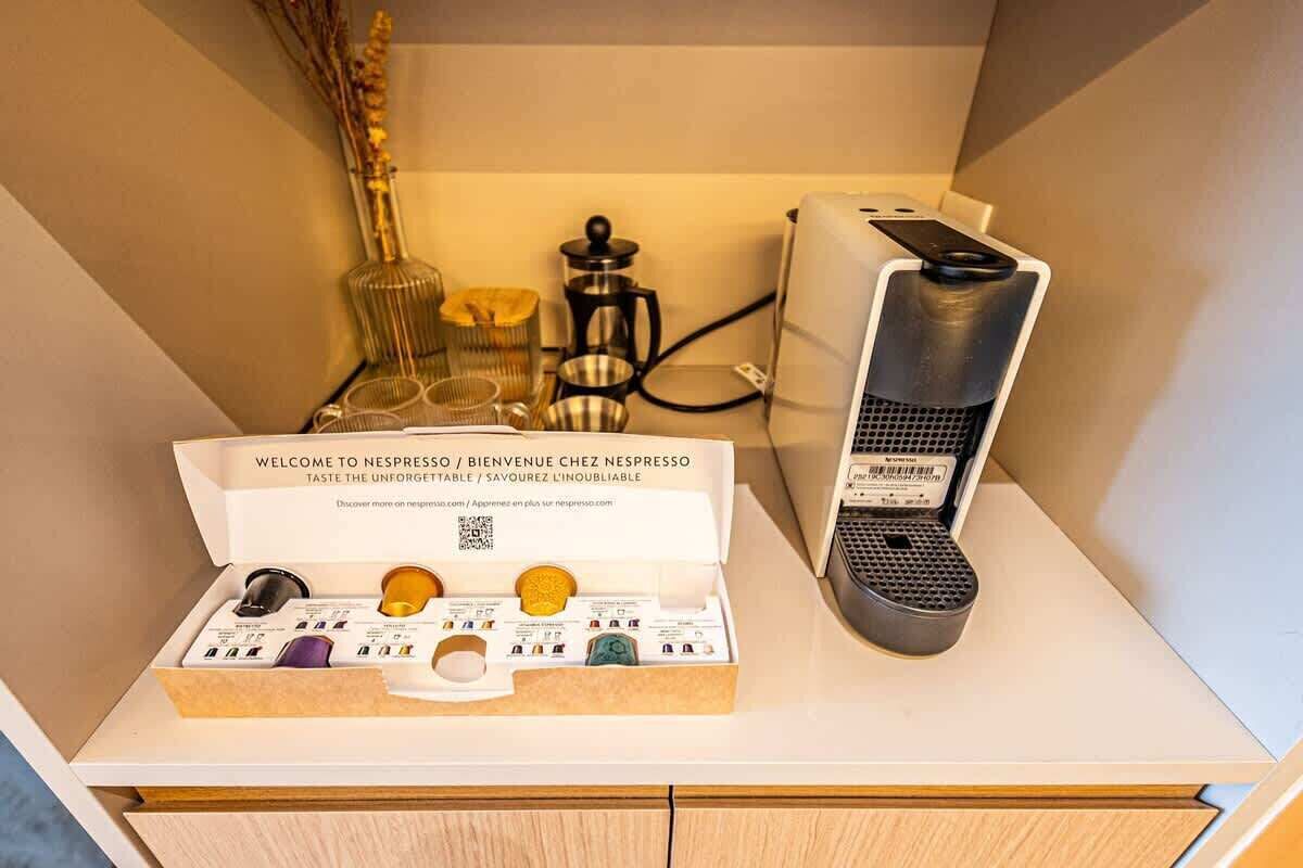 Eine Kaffeemaschine und eine Packung Nespresso-Kapseln auf einer Arbeitsplatte.