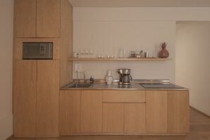 Eine moderne Küche mit Holzschnitzereien, integriertem Mikrowellenherd, einer Kaffeemaschine und einem Weinkühlsystem.