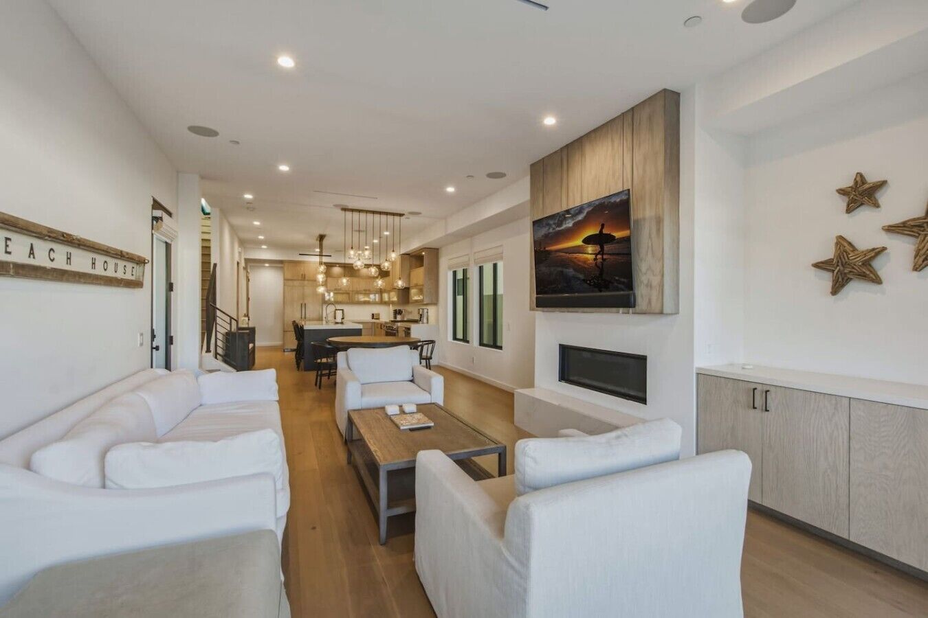 A modern living room with a sofa set, a coffee table, and a TV mounted on the wall.